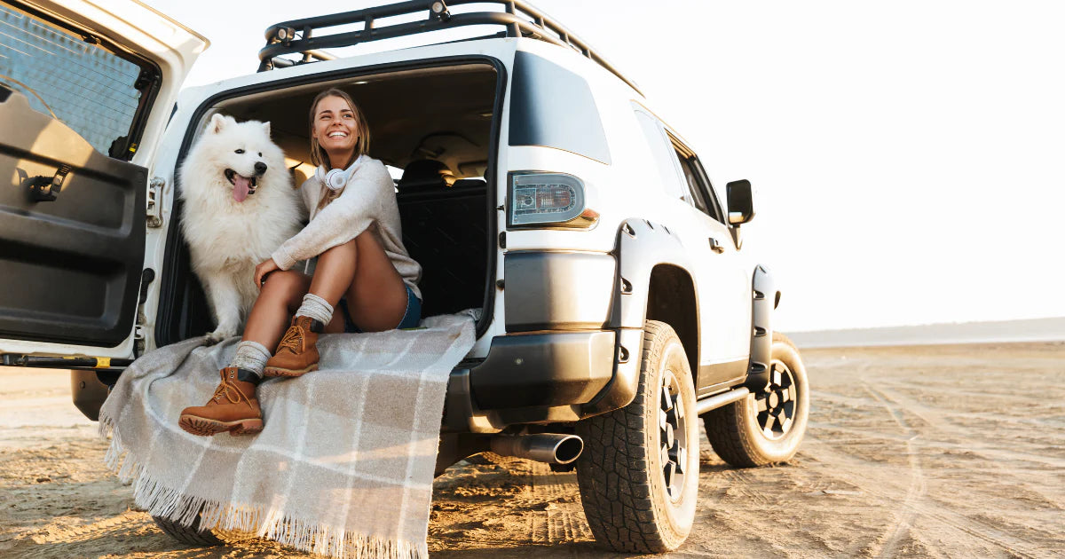 girl with dog in the back of an SUV