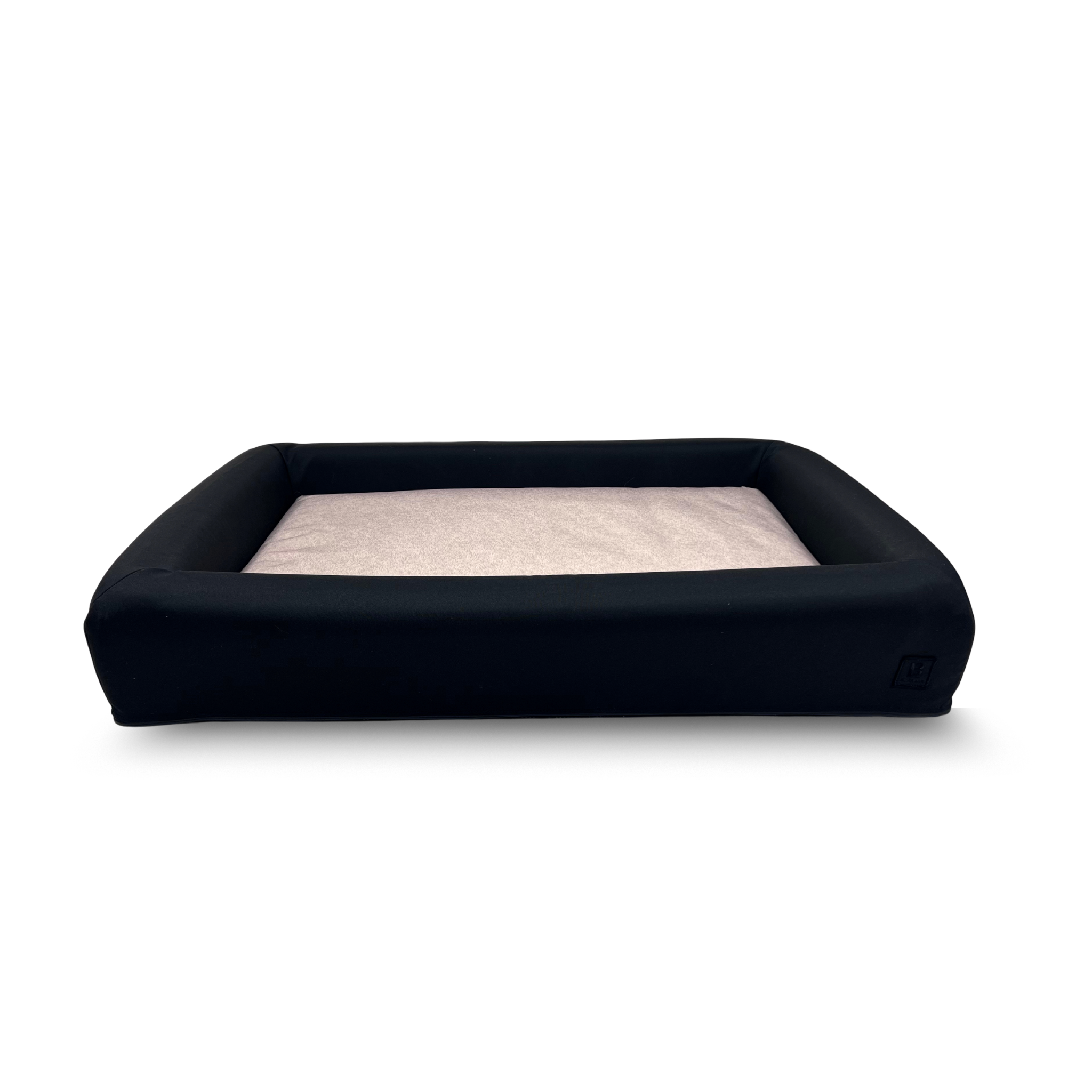Ecru waterproof dog bed with black bolster and removable washable covers.