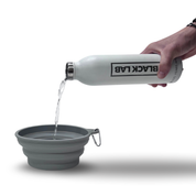 Water bottle pouring water into a collapsible travel dog bowl