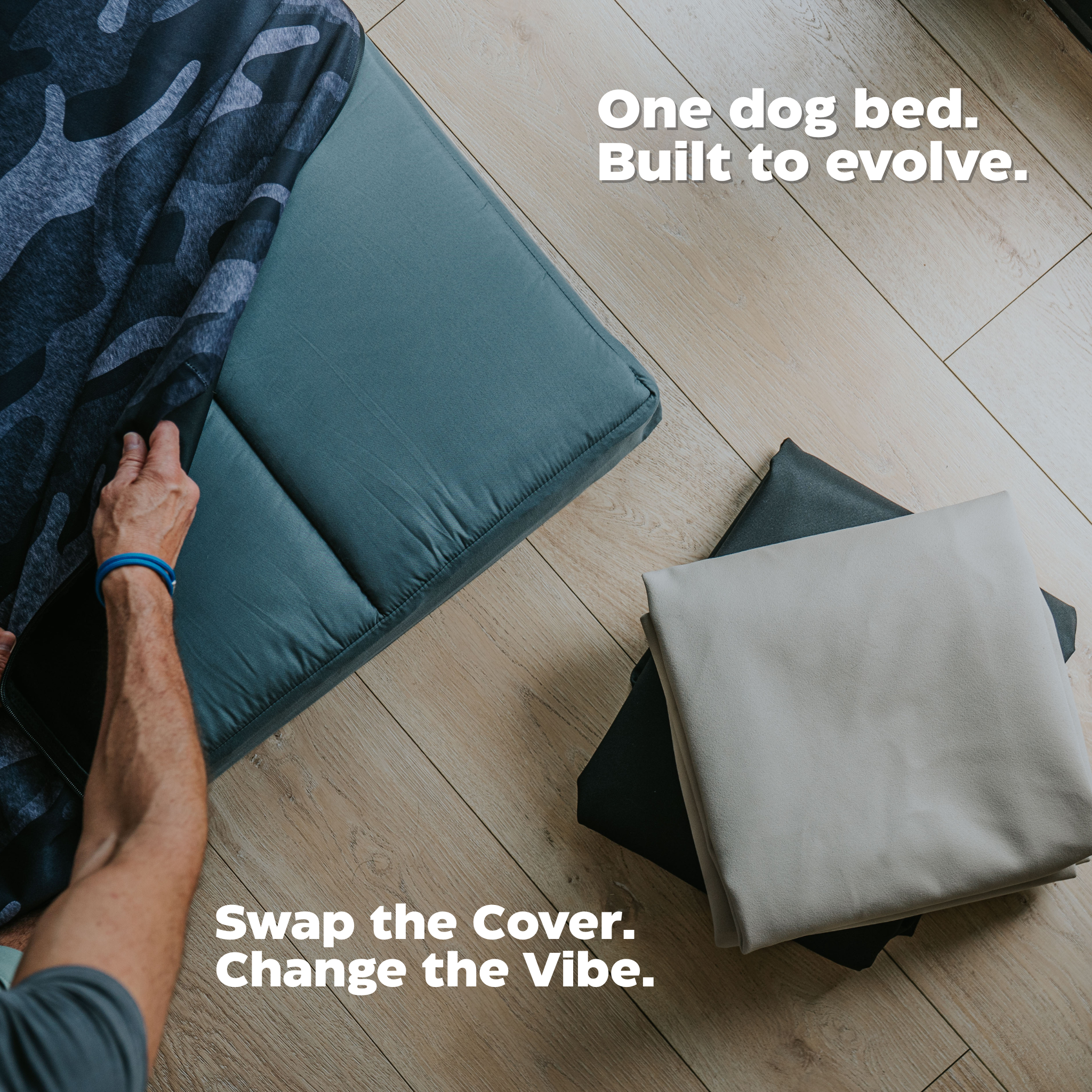 Dog bed with a changeable cover on a wooden floor, text 'One dog bed. Built to evolve.' and 'Swap the Cover. Change the Vibe.'